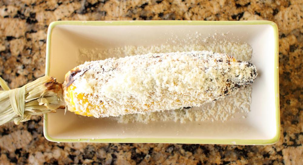 Cotija cheese sprinkled over cooked corn.