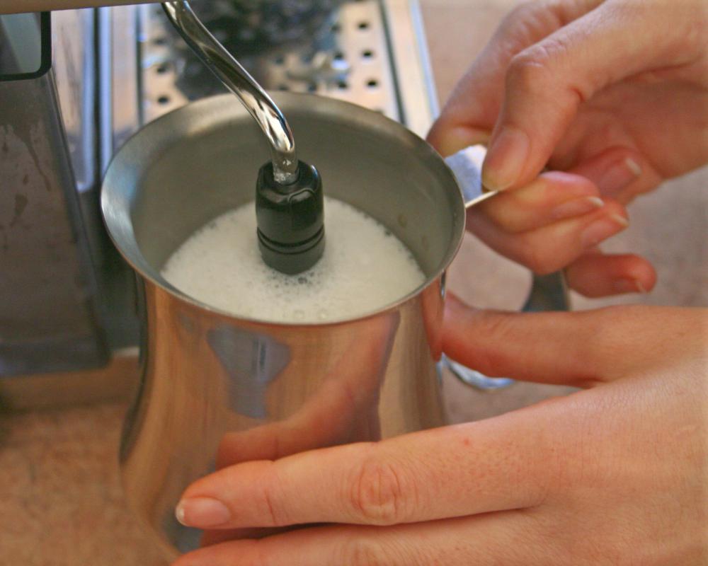 Frothing milk with a cappuccino machine.