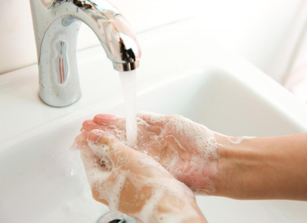 A person washing his hands in tap water.
