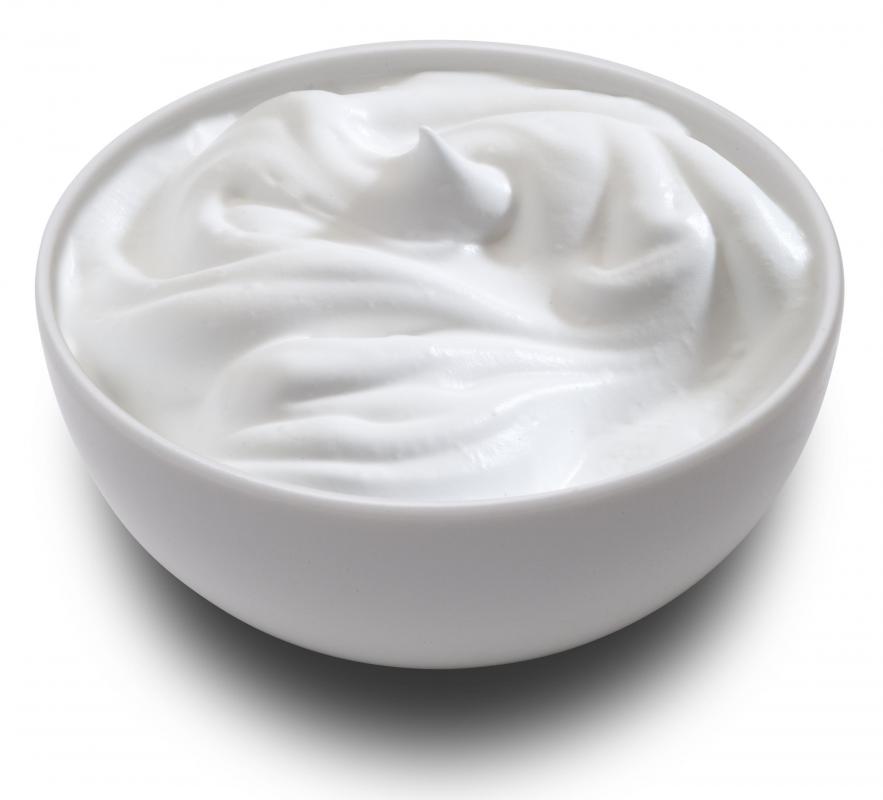 A bowl of sour cream, which can be used in making baked lemon cheesecake.