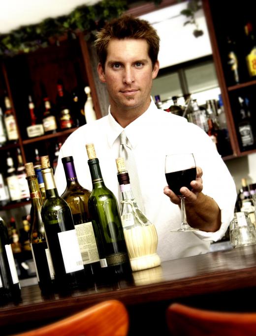 Bartender serving a glass of wine at an oyster bar.