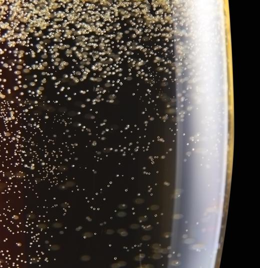 Fermentation gives off gas in champagne, producing bubbles.