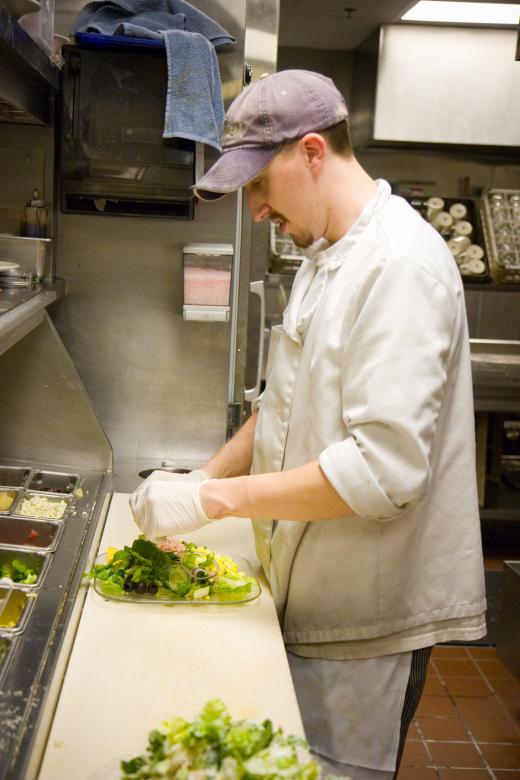 A chef should wear gloves for food sanitation safety.