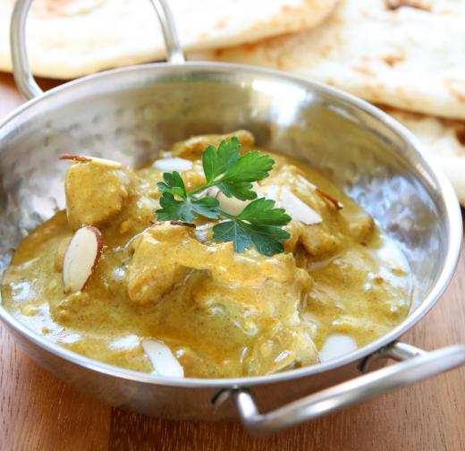 Sauteed chicken with korma sauce in a pan.