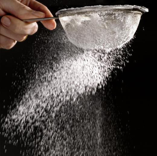 A baker sifting flour.