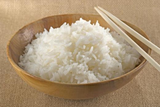 Cooked jasmine rice in a bowl with chopsticks.