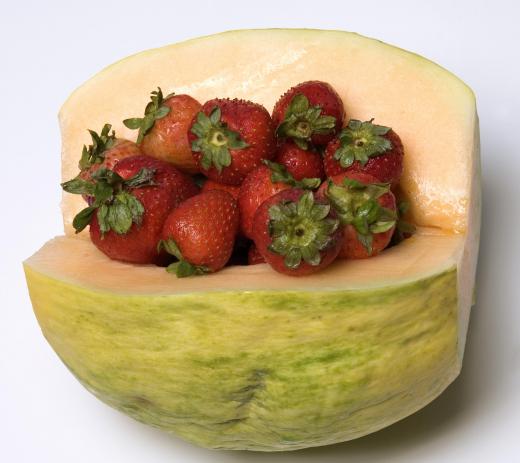 Cut crenshaw melon filled with hydroponic strawberries.