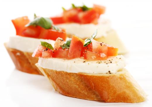 Crostini with mozzarella cheese, chopped tomato and basil.