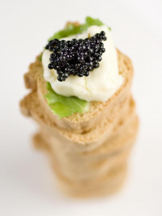 Caviar on melba toast with crème fraîche and basil.