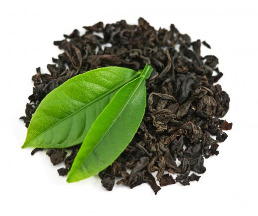 Looseleaf black tea with two fresh tea leaves.