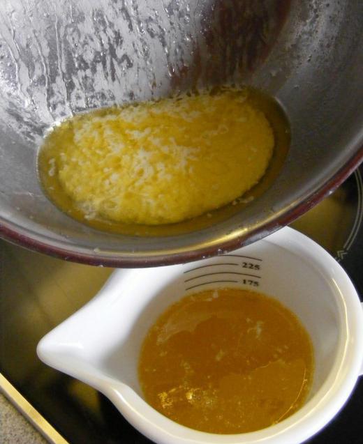 The leftover solids from making ghee, with a cup of ghee below.