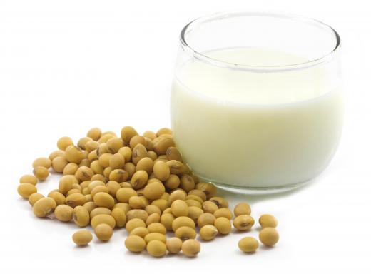 Soybeans beside a glass of soymilk.