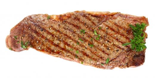 A steak with chopped parsley.