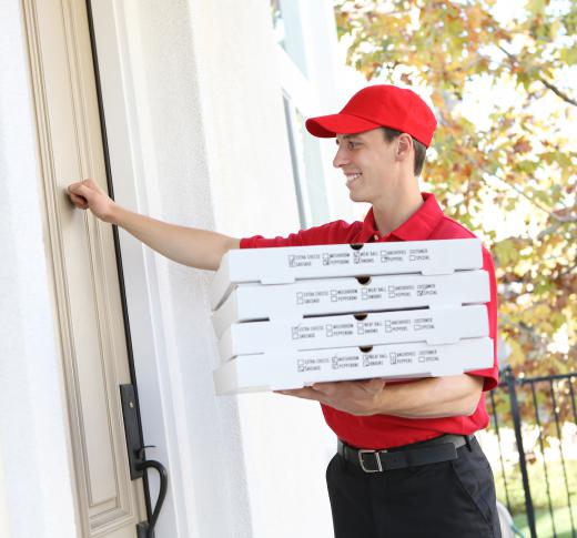 A man delivers pizza, including several with pepperoni.