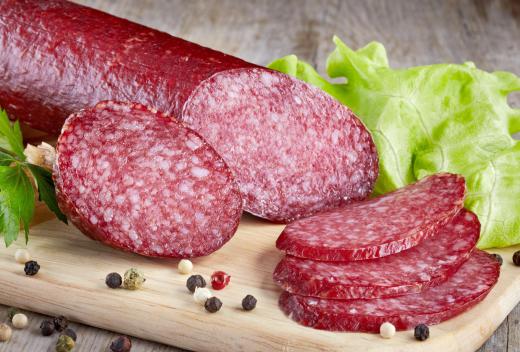 Ground meat is stuffed into a casing to make salami.