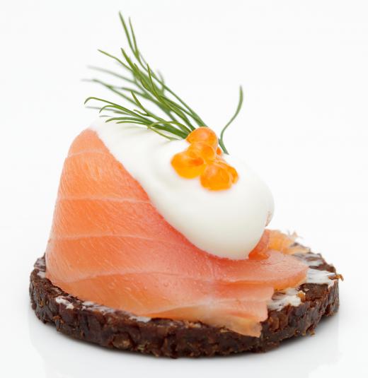 Salmon canapés with crème fraîche, salmon roe, and dill.