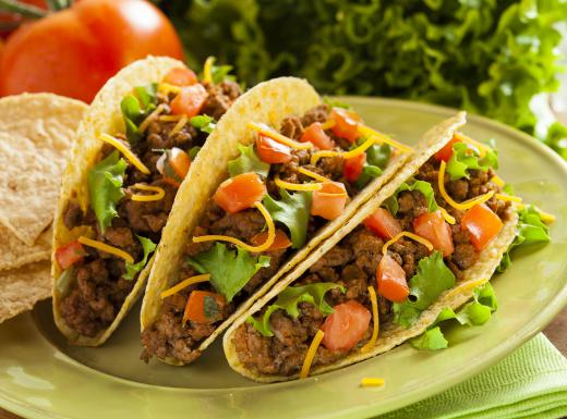 Tacos often contain beef, tomatoes, lettuce, and cheese.