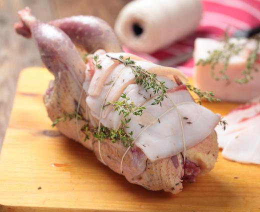 A classic use for kitchen twine is to truss a chicken with herbs before roasting.