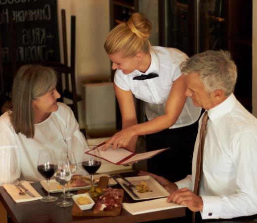 A waitress explains the menu to her customers.