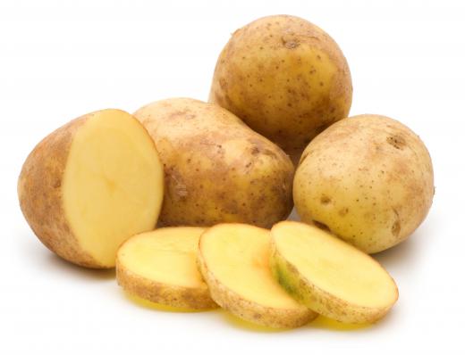 Whole and sliced raw potatoes.